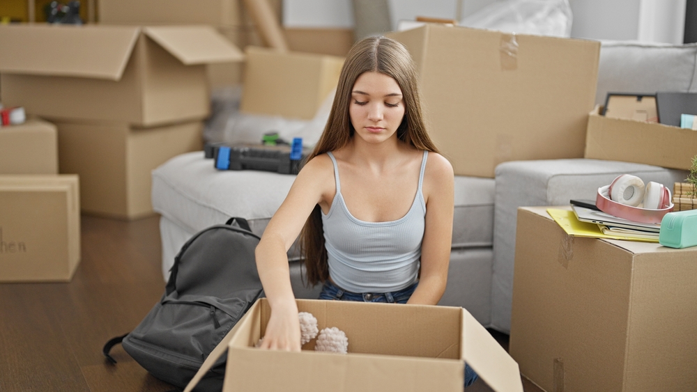 Young woman packing moving boxes.